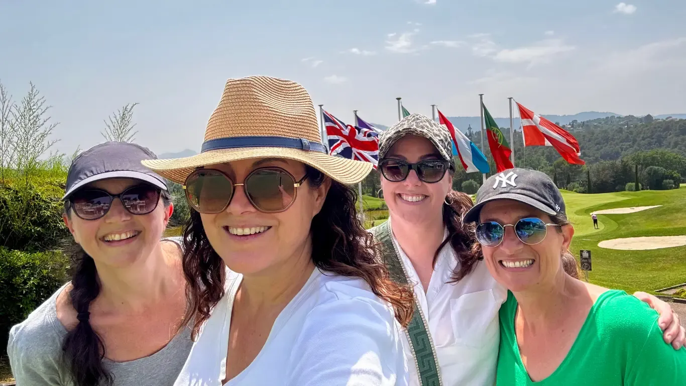 Estelle Hubert, Stephanie Matard, Valérie Marinelli et Gaëlle Bétend, comédiennes voix off, souriantes devant les drapeaux d’un parcours de golf, en week-end à Nice