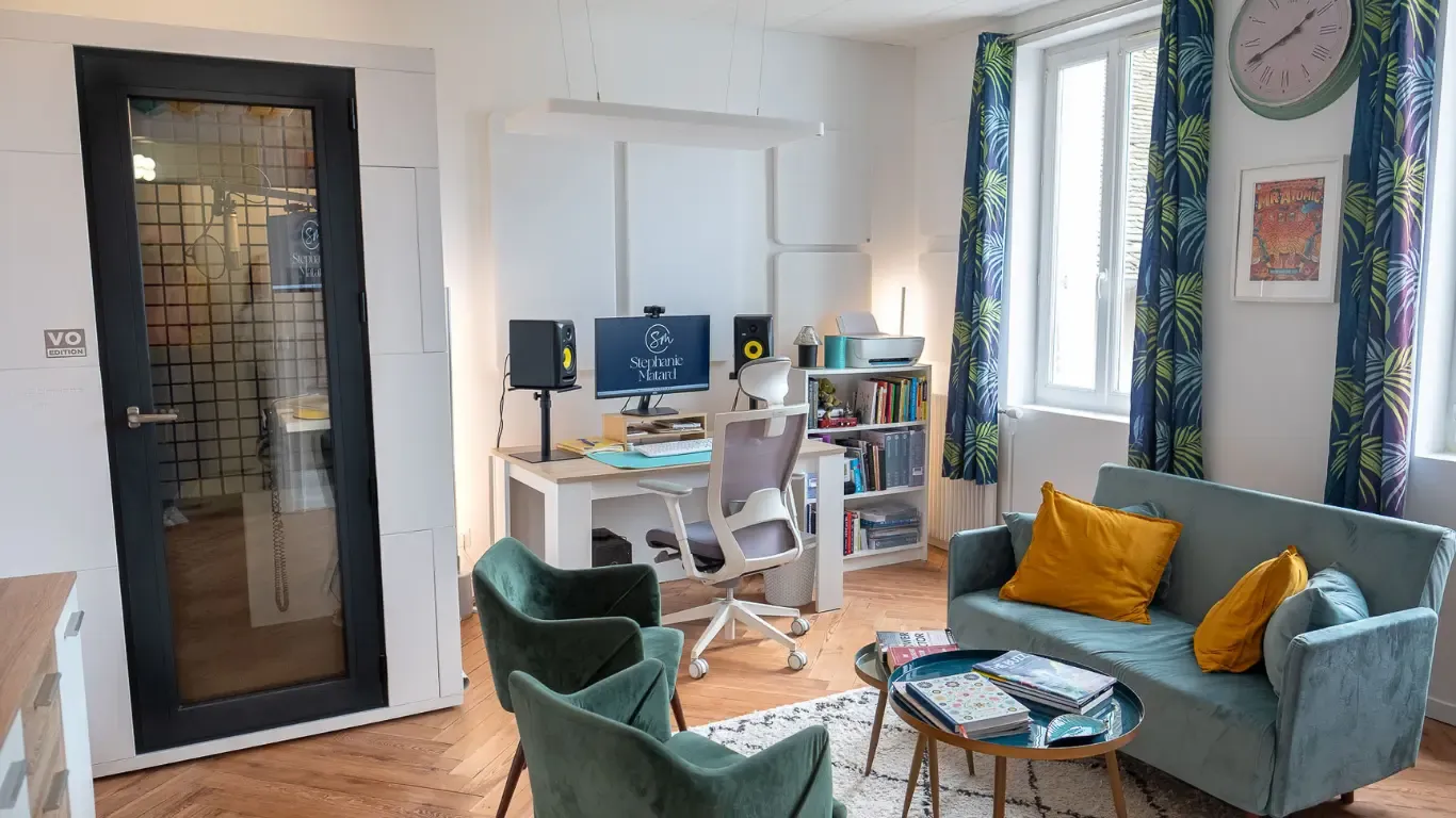 Vue d’ensemble du studio de Stephanie Matard : la porte vitrée de sa cabine, le bureau et le canapé