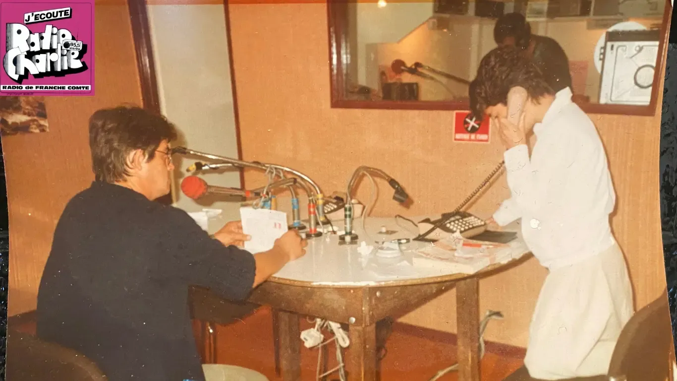 An archive photograph in the Radio Charlie studio: a presenter at the mixing desk and Estelle on the station’s phone