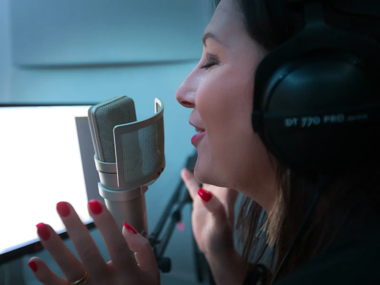 Estelle Hubert au micro, les yeux fermés, casque Beyerdynamic DT 770 Pro sur les oreilles