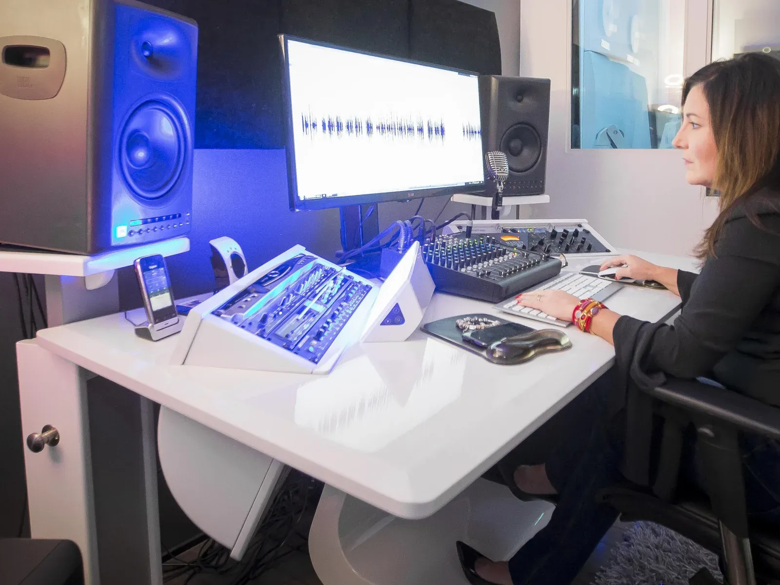 Main studio control room: Estelle Hubert at her Zaor studio desk, an audio waveform on screen and a JBL monitor lit in blue