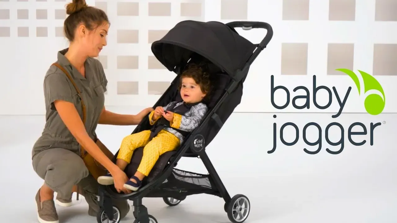 A mother leaning over her child in a pushchair, with the Baby Jogger logo