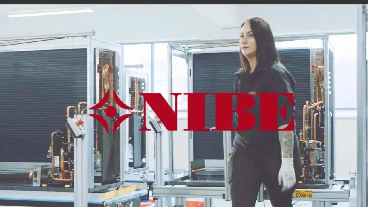 Technicienne devant des pompes à chaleur en production, logo NIBE