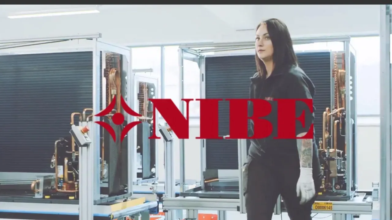 Technicienne devant des pompes à chaleur en production, logo NIBE