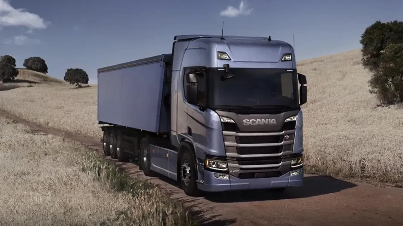 Camion Scania sur une route au milieu des champs de céréales