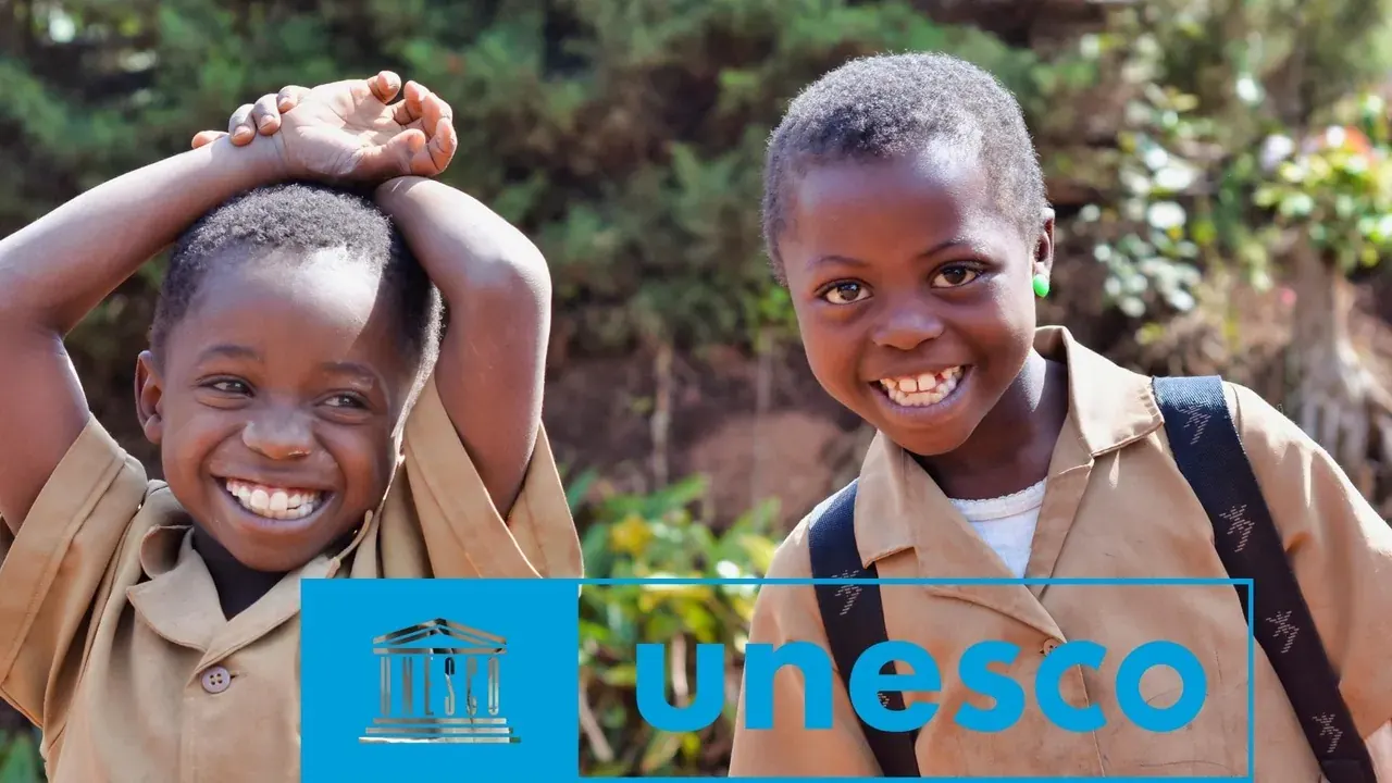 Deux écoliers souriants en uniforme, cartable sur le dos, logo de l’UNESCO