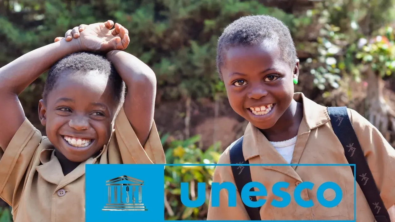 Two smiling schoolchildren in uniform with schoolbags, beside the UNESCO logo