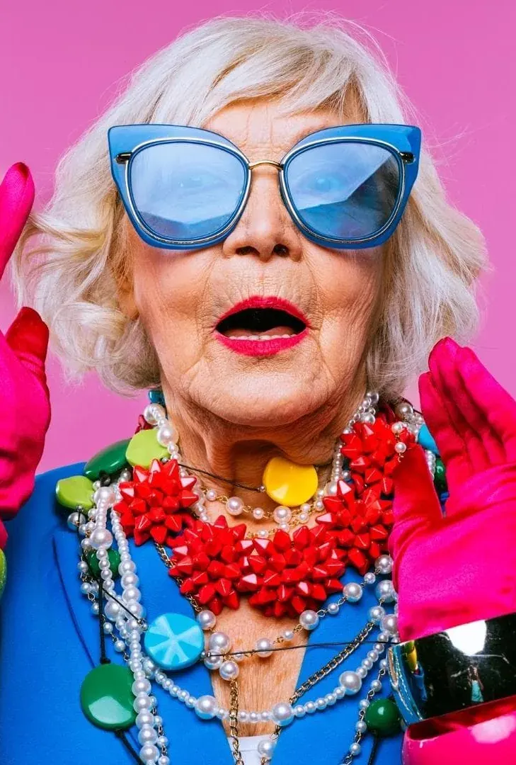 Mamie loufoque aux grandes lunettes bleues et aux bijoux colorés, personnage interprété par Estelle Hubert, comédienne voix off