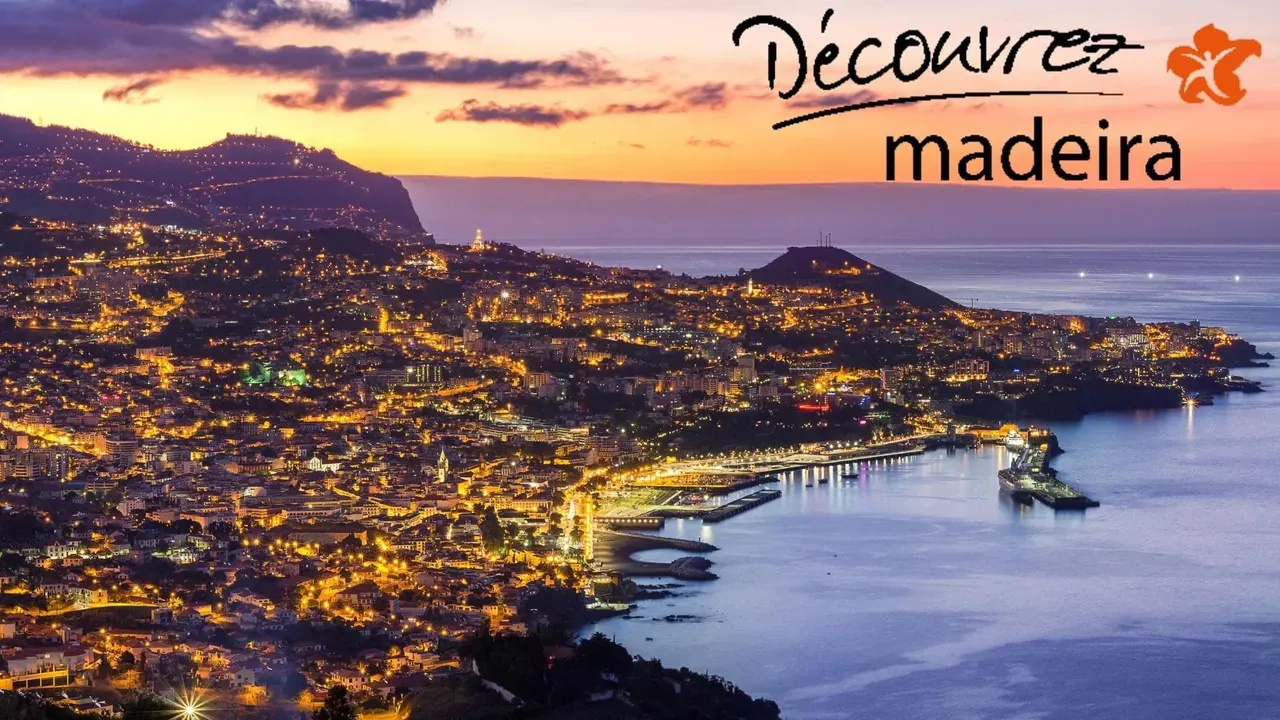 Ville côtière illuminée au crépuscule et signature « Découvrez madeira »
