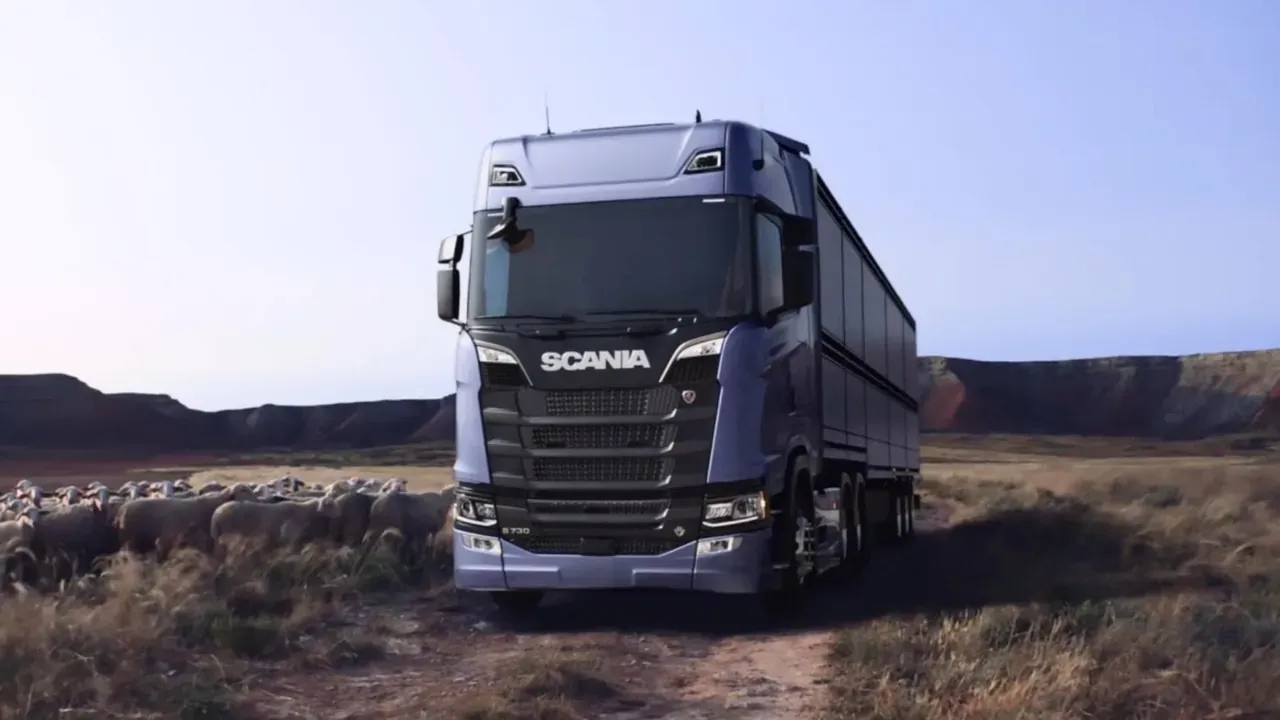 Camion Scania sur un chemin de terre, à côté d’un troupeau de moutons