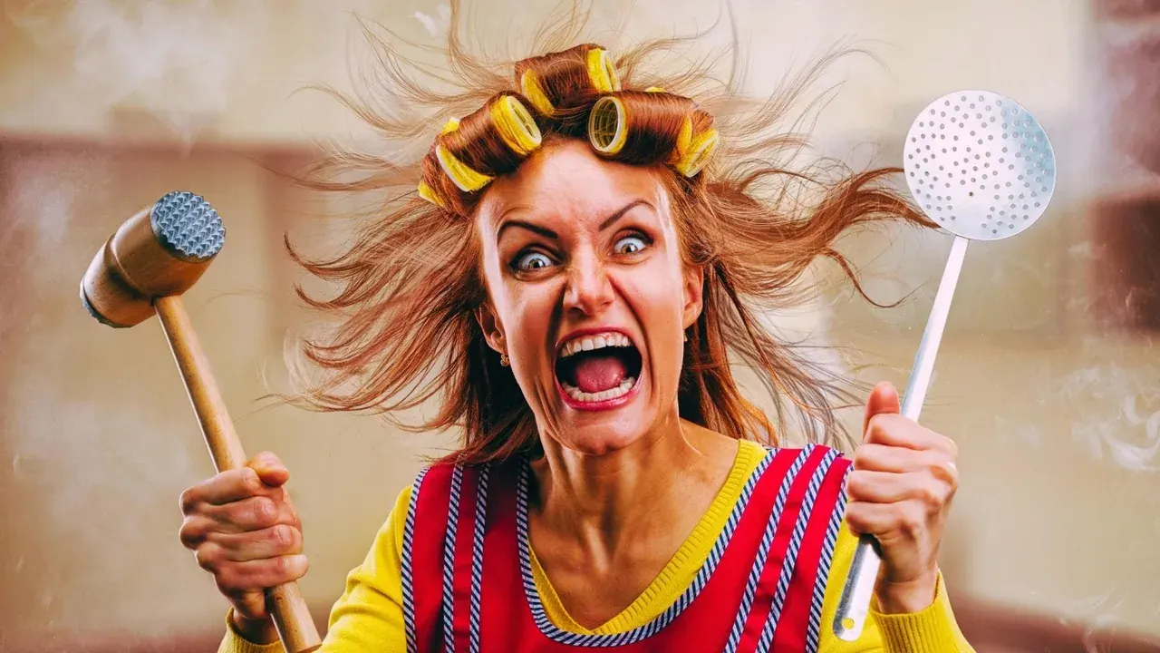 Femme aux bigoudis, un maillet à viande et une écumoire levés, expression exagérée