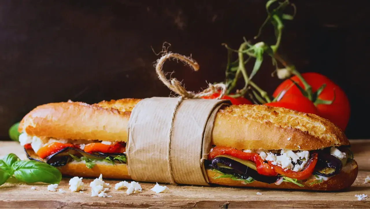 Sandwich baguette garni, tomates et feuilles de basilic