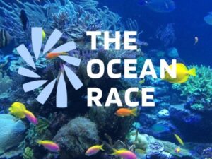 Logo The Ocean Race sur un fond marin tropical avec des coraux et des poissons colorés, illustrant la richesse des océans.