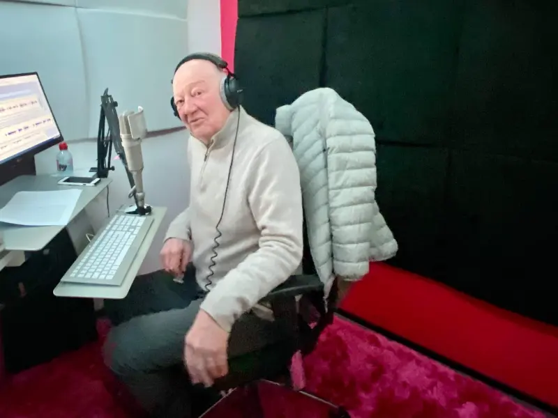 Benoît Allemane in a professional studio, headphones on, ready to record.